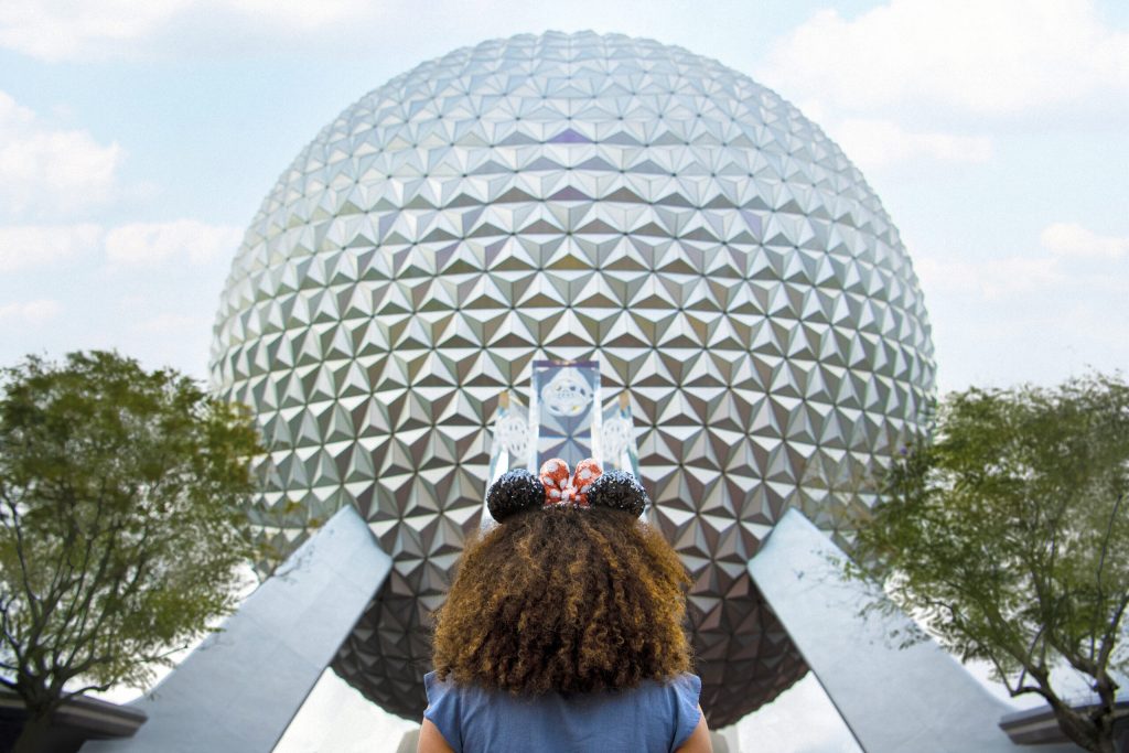 Solo travel fan standing outside Spaceship Earth at EPCOT